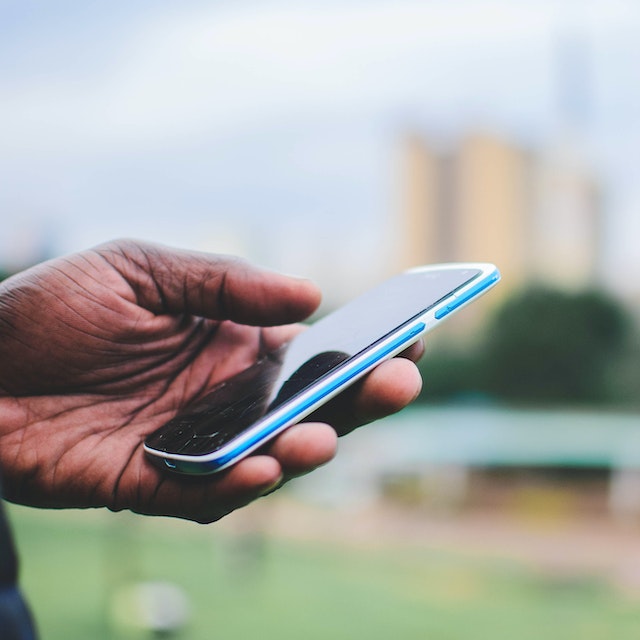 Mano de un hombre sosteniendo un celular que tiene abierto el sitio web de Simlimites